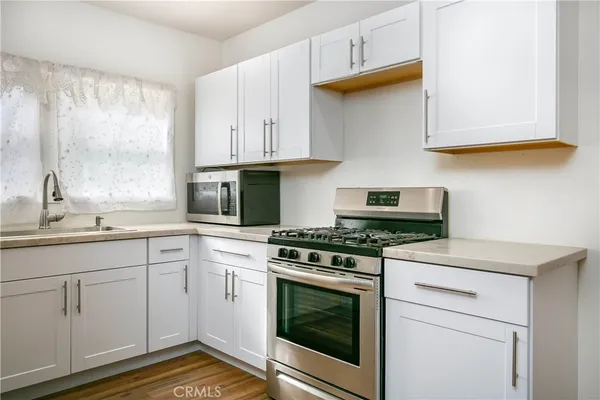 a kitchen with cabinets appliances and a window