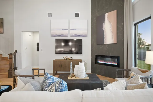 a living room with furniture a flat screen tv and a fireplace