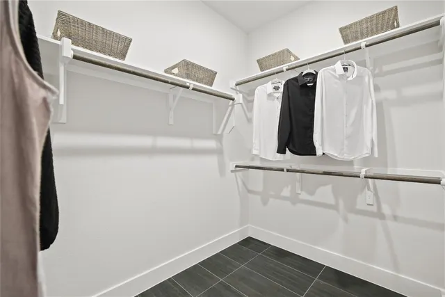 a view of walk in closet with clothes and shoes