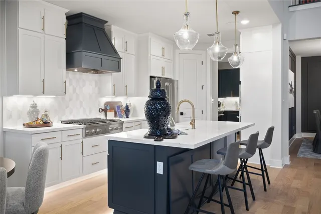 a kitchen with kitchen island granite countertop a sink cabinets and stainless steel appliances