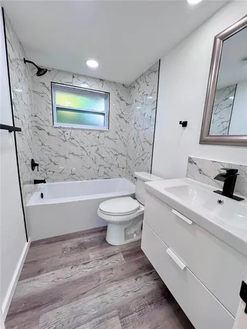 a bathroom with a toilet a sink and bathtub
