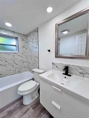 a bathroom with a sink toilet a mirror and shower
