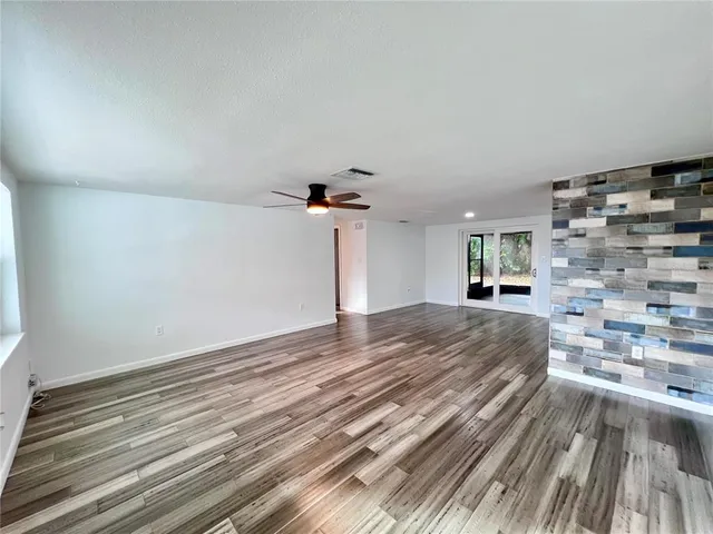 a view of empty room with wooden floor