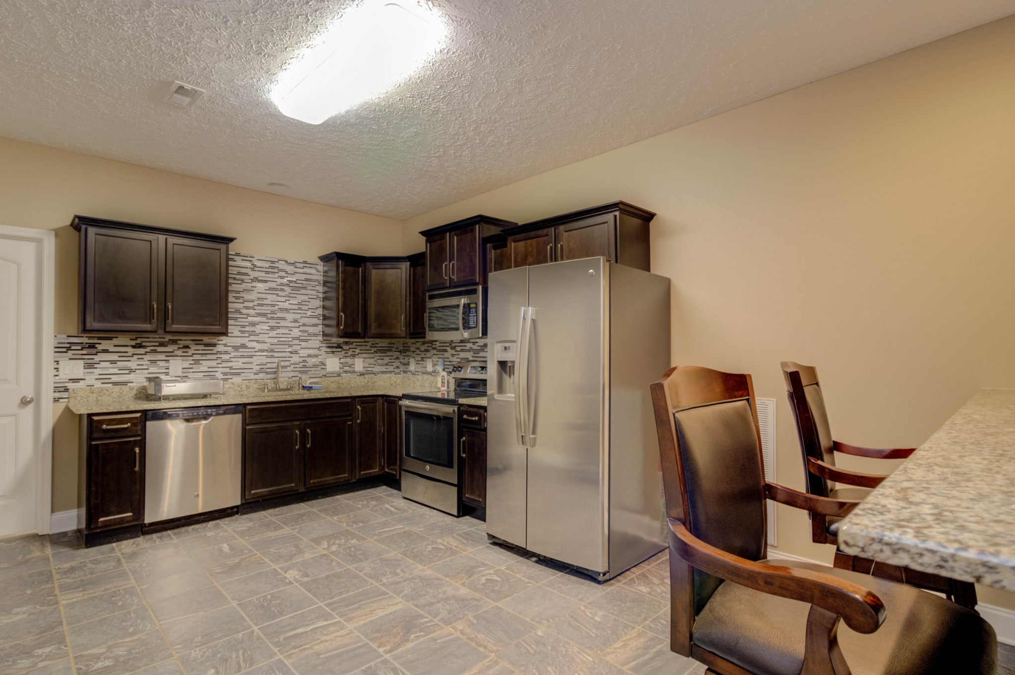 4190 Trough Springs Road Adams, TN 37010 - Photo 33 of 50 a kitchen with stainless steel appliances granite countertop a refrigerator and a stove top oven