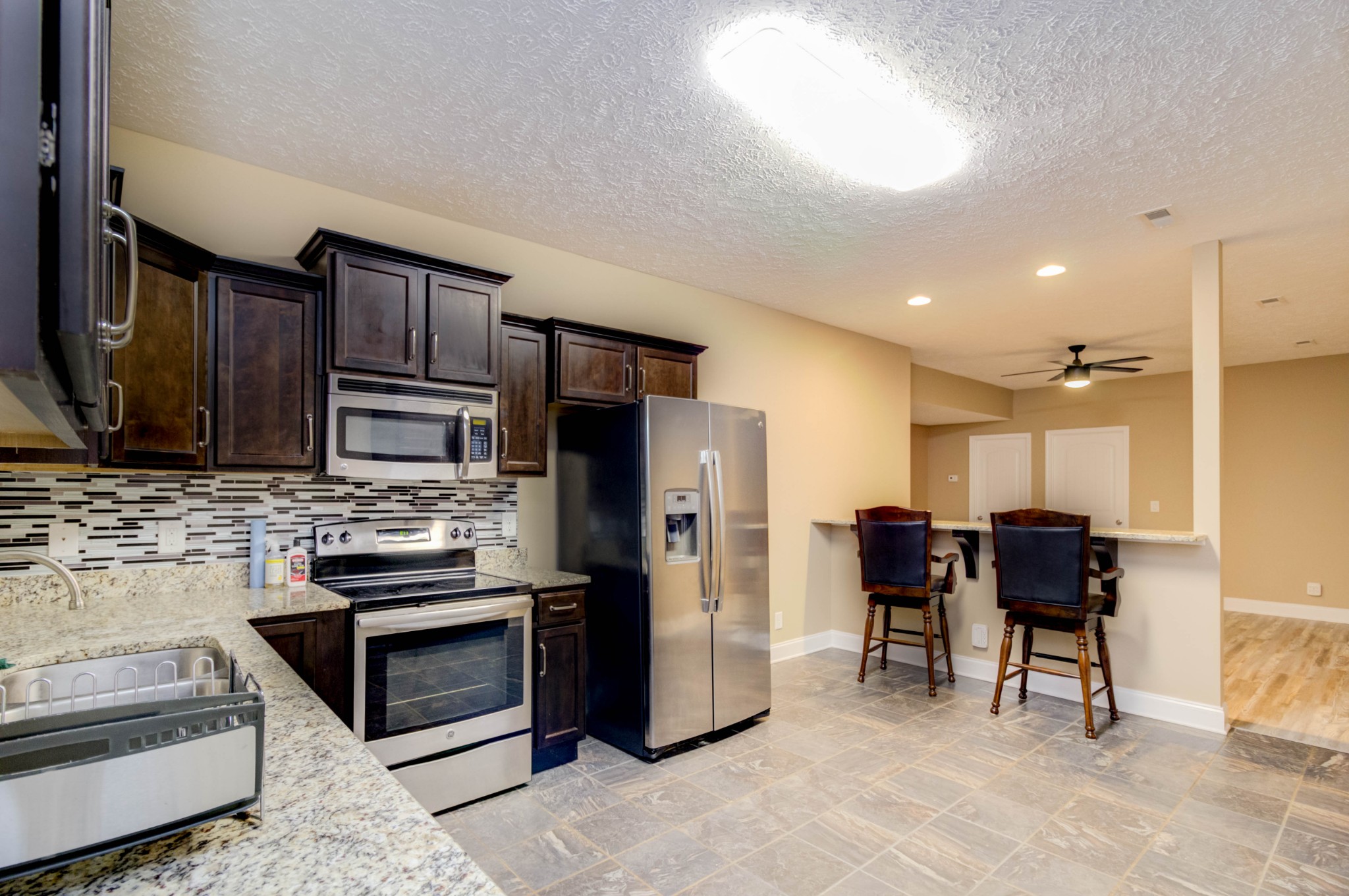 4190 Trough Springs Road Adams, TN 37010 - Photo 34 of 50 a kitchen with stainless steel appliances kitchen island granite countertop a refrigerator and a stove top oven