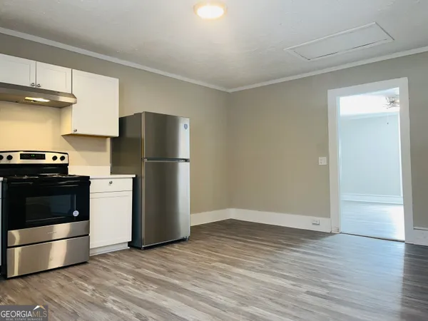 a kitchen with a refrigerator and a stove top oven