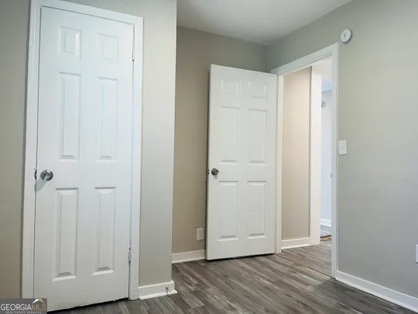 an empty room with wooden floor and closet area