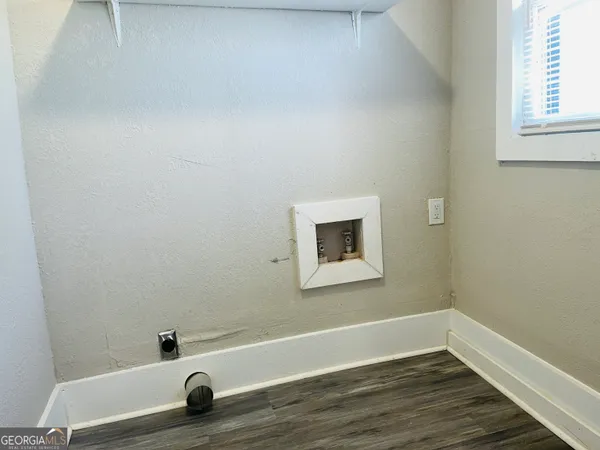 a view of a small space with wooden floor and a window