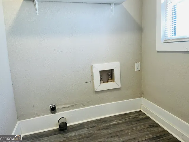 a view of a small space with wooden floor and a window
