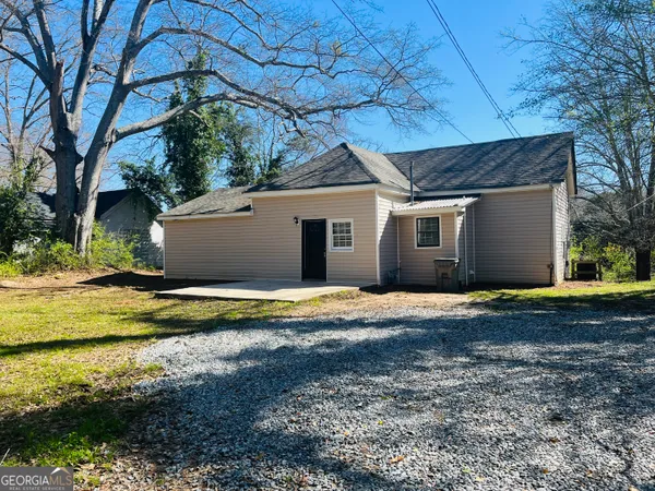 a view of a house with a yard and large tree