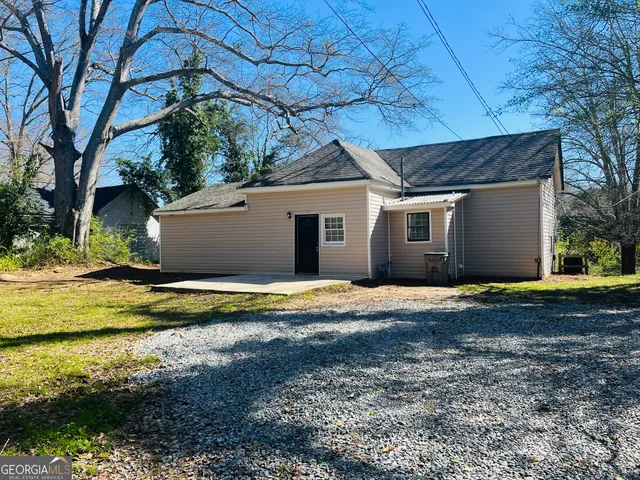 a view of a house with a yard and large tree