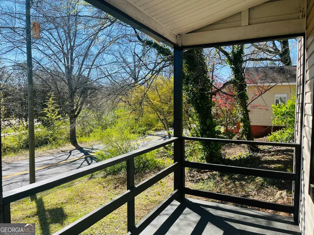 a view of trees and cars from a balcony