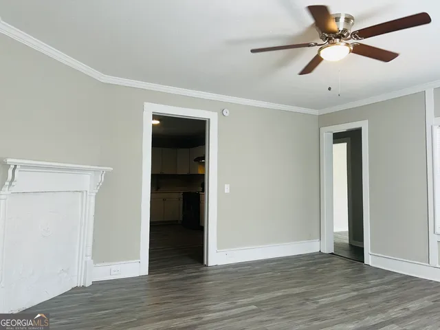 an empty room with wooden floor and ceiling fan