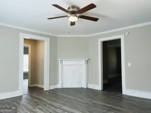 a view of an empty room with wooden floor