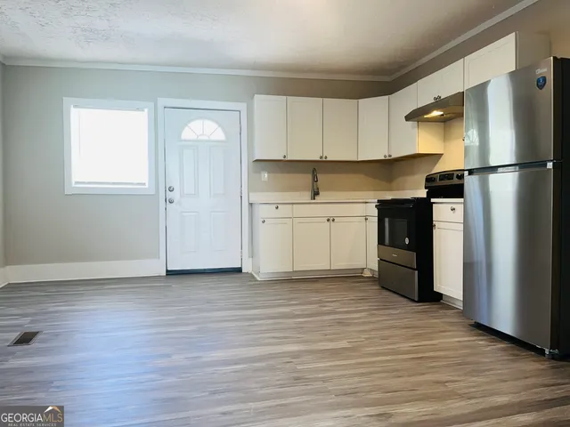 a kitchen with stainless steel appliances granite countertop a refrigerator and a stove top oven