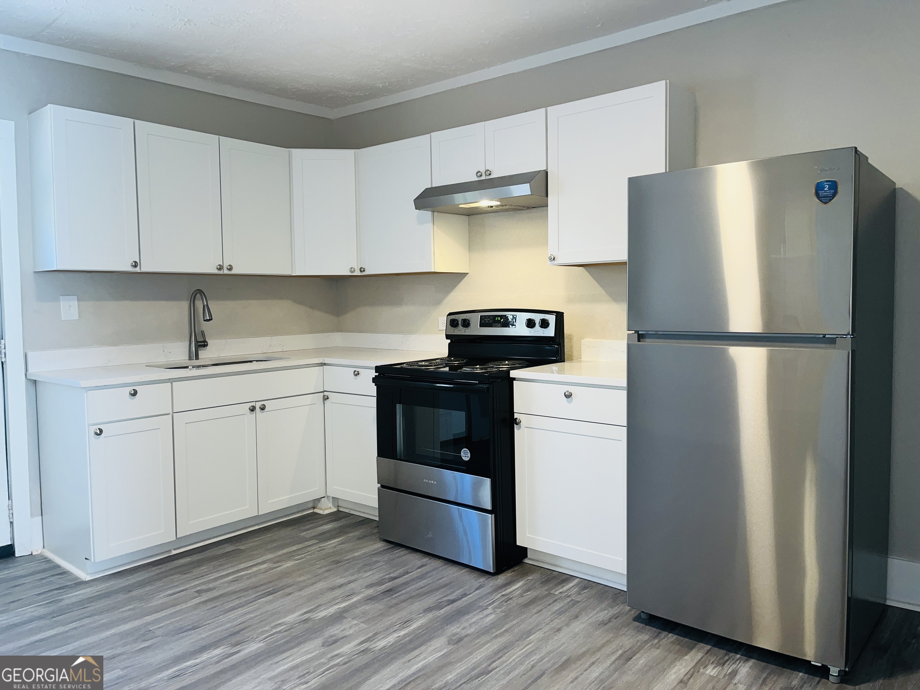 1318 Forrest Avenue LaGrange, GA 30240 - Photo 10 of 23 a kitchen with a refrigerator sink and cabinets