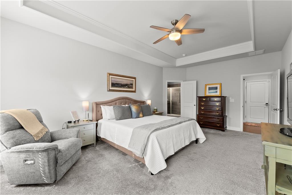 527 Gadwall Circle Jefferson, GA 30549 - Photo 15 of 42 a spacious bedroom with a bed a couch and a chandelier