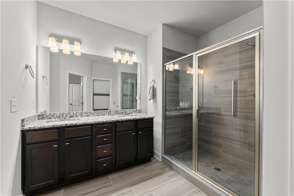 527 Gadwall Circle Jefferson, GA 30549 - Photo 17 of 42 a bathroom with a granite countertop sink shower and a mirror