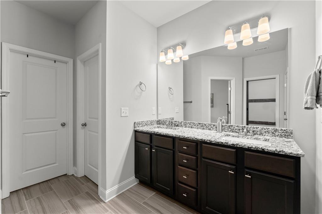 527 Gadwall Circle Jefferson, GA 30549 - Photo 18 of 42 a bathroom with a granite countertop sink and a mirror