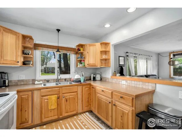 a open kitchen with stainless steel appliances granite countertop a stove a sink dishwasher a refrigerator white cabinets and wooden floor