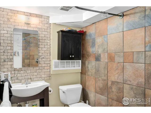 a bathroom with a sink a toilet and a window