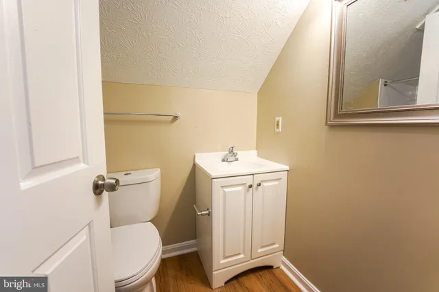 a bathroom with a toilet a sink and mirror