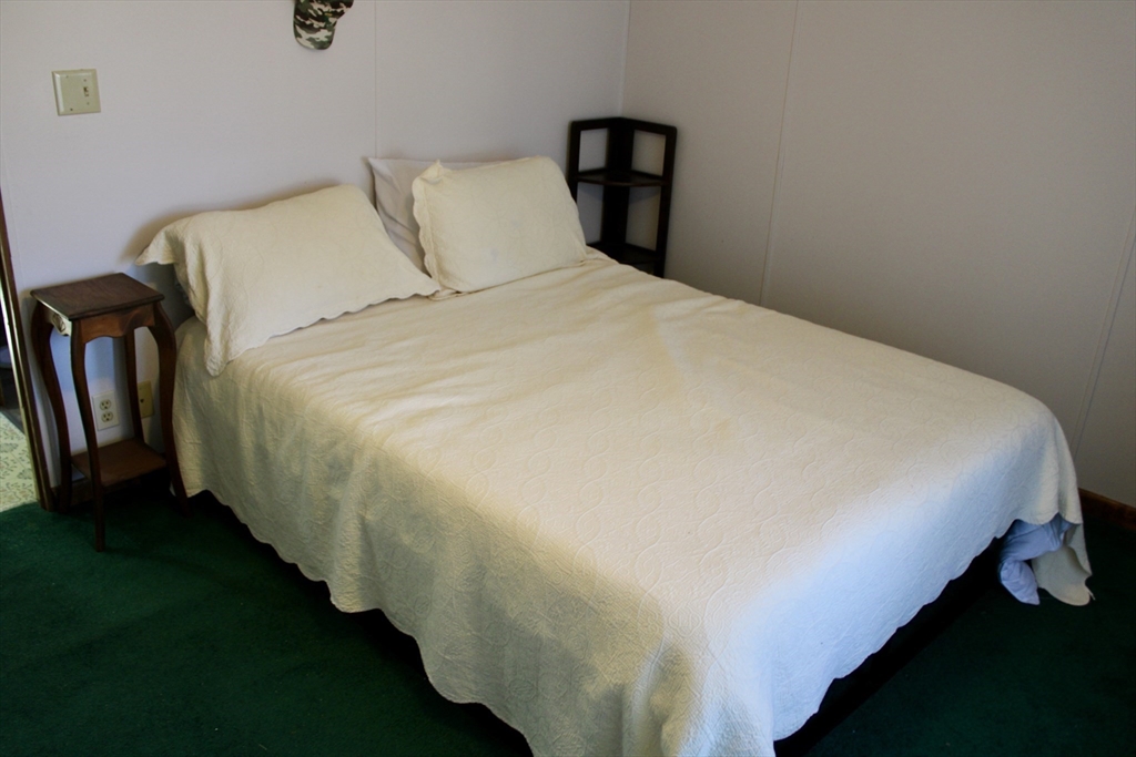 75 South Street, Unit 3 Bernardston, MA 01337 - Photo 19 of 20 a bed sitting in a bedroom next to a window with rug