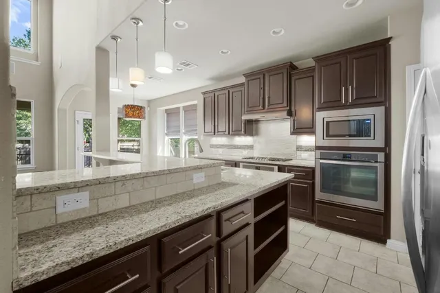 a kitchen with stainless steel appliances granite countertop a sink stove and refrigerator