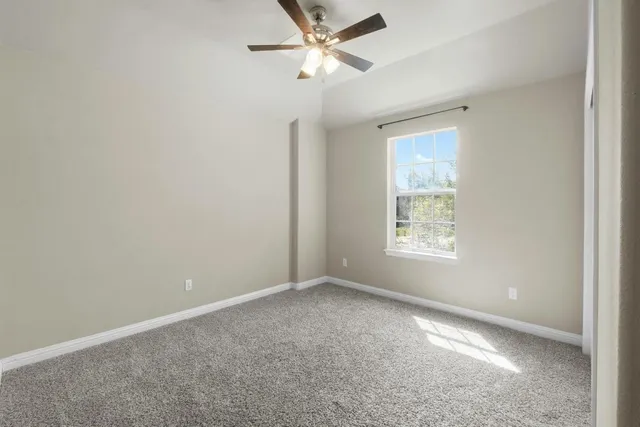 an empty room with a window and a fan