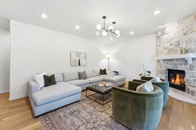 1712 Somerset Ridge Drive Draper, UT 84020 - Photo 28 of 76 Spacious living area featuring a stone fireplace with a substantial mantel, wood-finish flooring, recessed lighting, and a contemporary spherical chandelier
