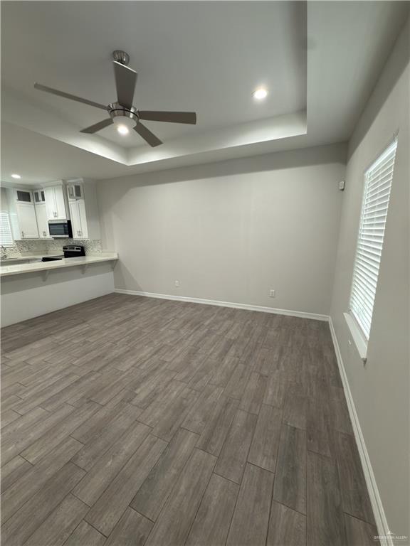 1619 Playa Drive, Unit 1 Weslaco, TX 78596 - Photo 4 of 11 an empty room with wooden floor fan and windows