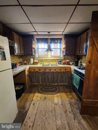 a kitchen with a sink a stove top oven a refrigerator and a dishwasher
