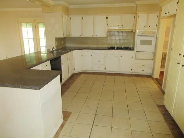 a kitchen with stainless steel appliances a sink a stove a refrigerator and cabinets