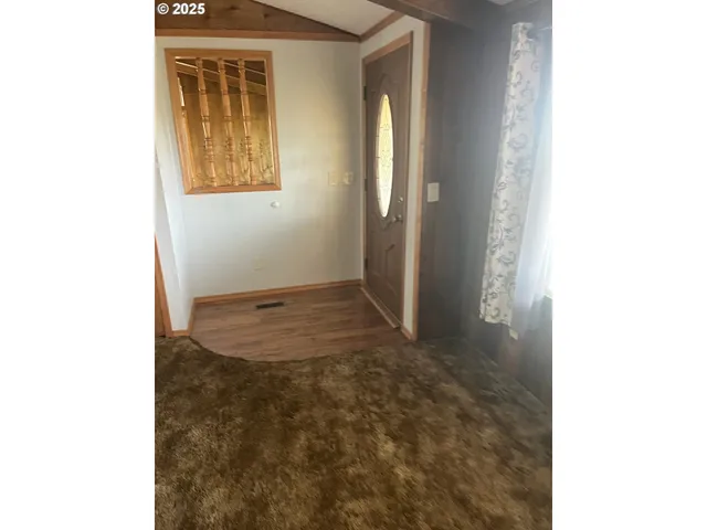 a view of a room with wooden floor and a window