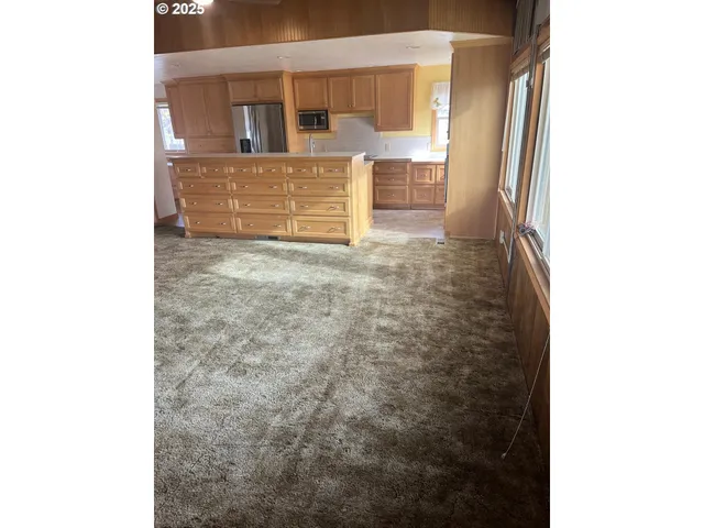 a kitchen with stainless steel appliances granite countertop a refrigerator a stove and a sink