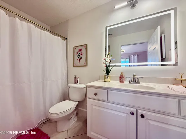 a bathroom with a toilet a sink and a mirror