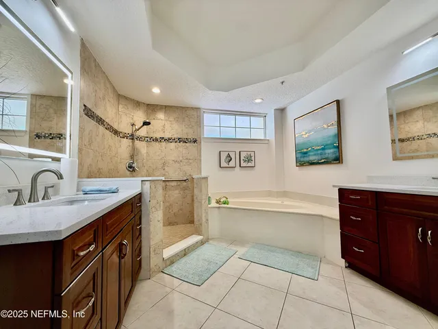 a spacious bathroom with a granite countertop sink mirror and bathtub