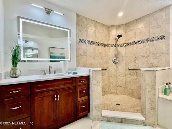 a bathroom with a shower sink and mirror