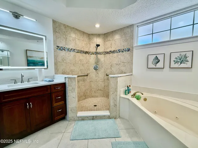 a bathroom with a bathtub shower sink and mirror