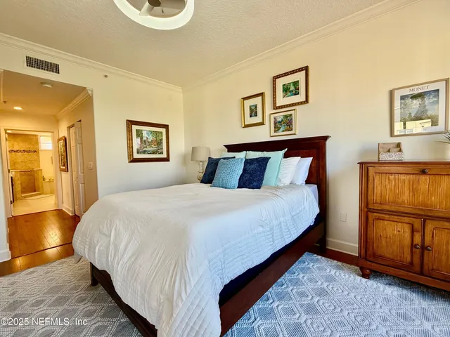 a bedroom with a bed and painting on the wall