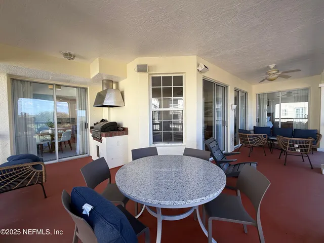 a living room with furniture a table and kitchen view