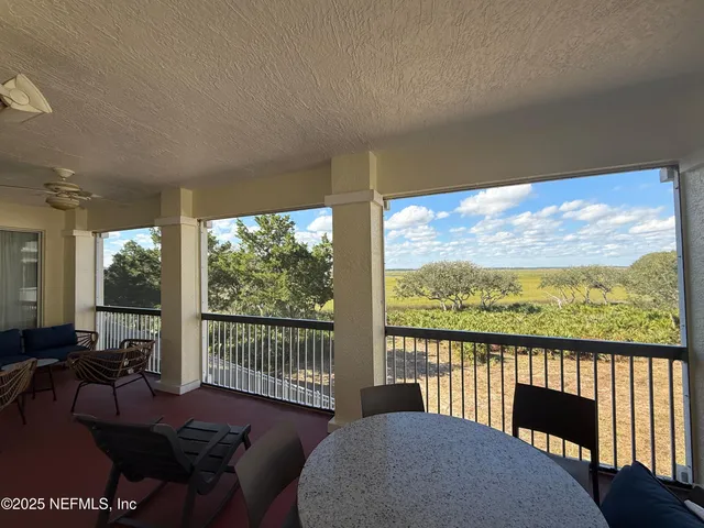 a living room with furniture tv and large windows