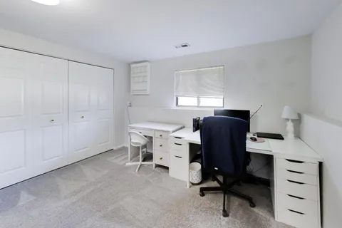 a view of a workspace with furniture and a window