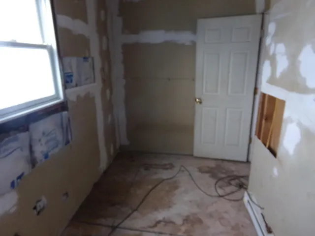 an empty room with chandelier fan