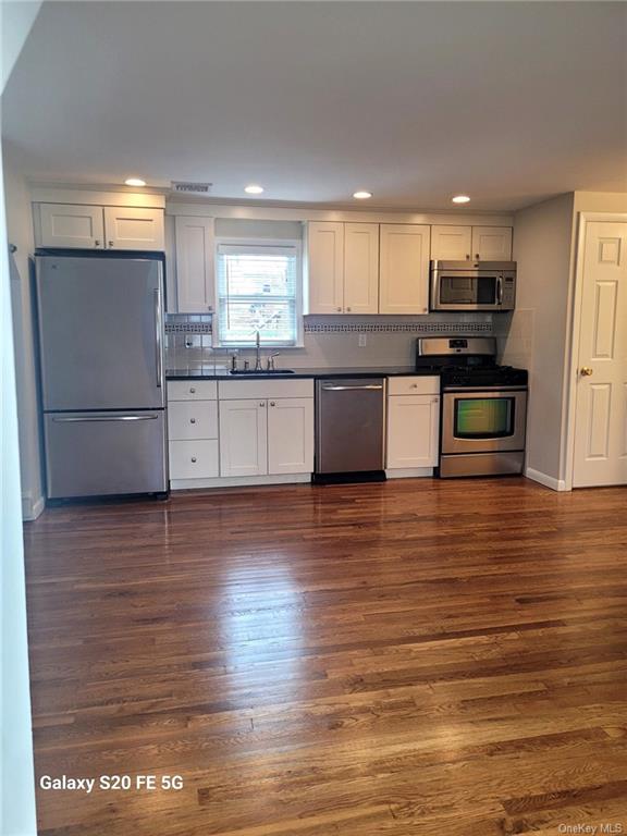 a large kitchen with stainless steel appliances granite countertop a stove and a refrigerator