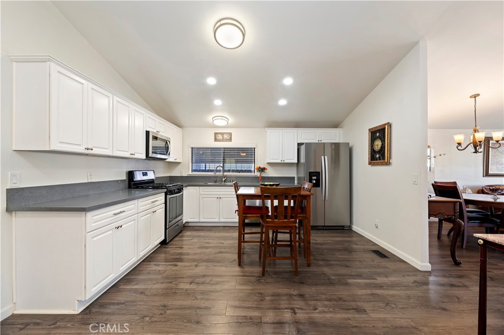 27250 Murrieta Road, Unit 120 Menifee, CA 92586 - Photo 16 of 46 a kitchen with stainless steel appliances kitchen island granite countertop a table chairs sink and cabinets