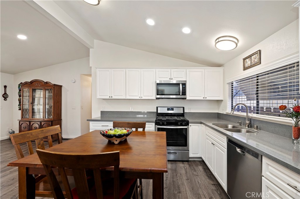 27250 Murrieta Road, Unit 120 Menifee, CA 92586 - Photo 18 of 46 a kitchen with stainless steel appliances granite countertop a kitchen island hardwood floor sink stove dining table and chairs