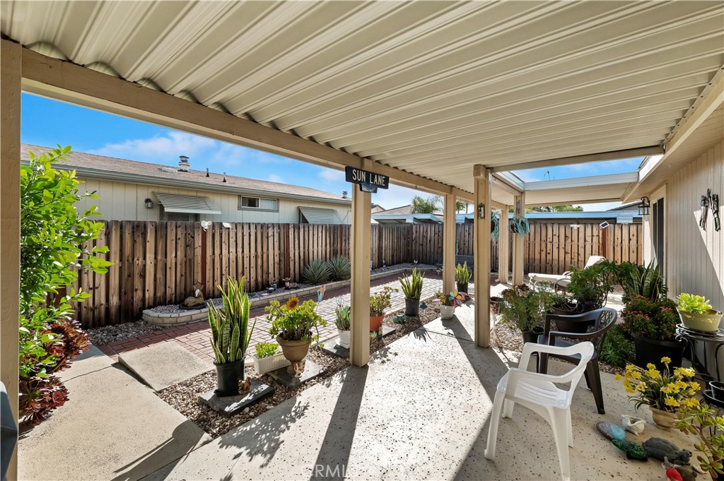 27250 Murrieta Road, Unit 120 Menifee, CA 92586 - Photo 26 of 46 a view of a patio with table and chairs potted plants and floor to ceiling window