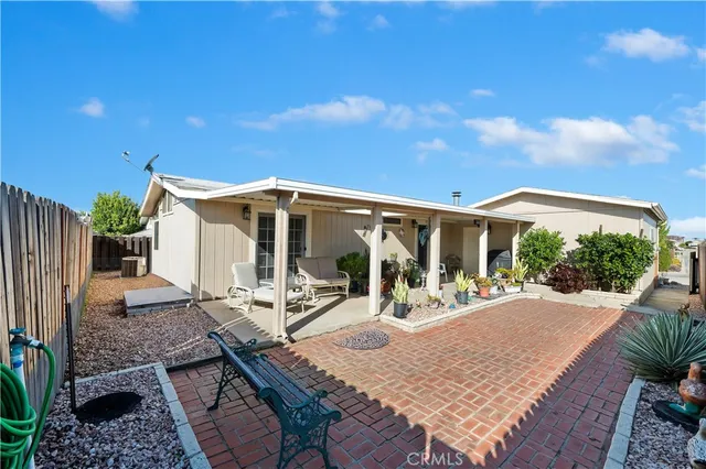 a view of a house with patio and wooden fence