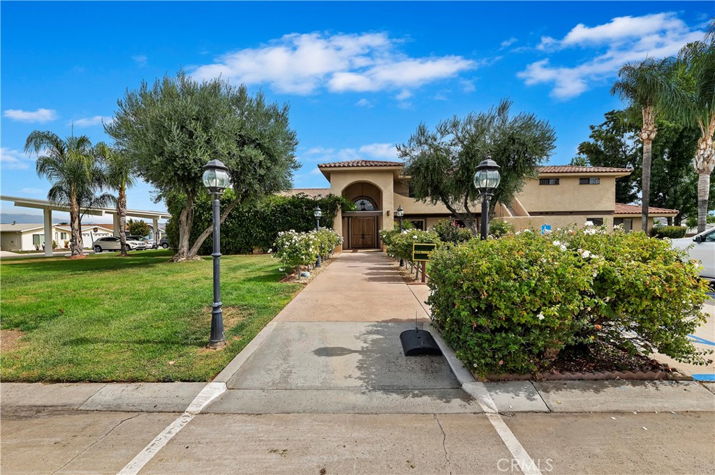 27250 Murrieta Road, Unit 120 Menifee, CA 92586 - Photo 31 of 46 a front view of a house with a yard and potted plants